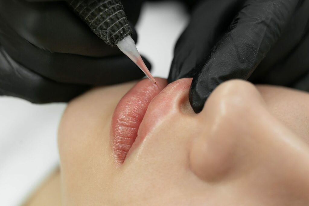 Close-up of the permanent makeup procedure. Lip makeup in the cosmetologist's salon